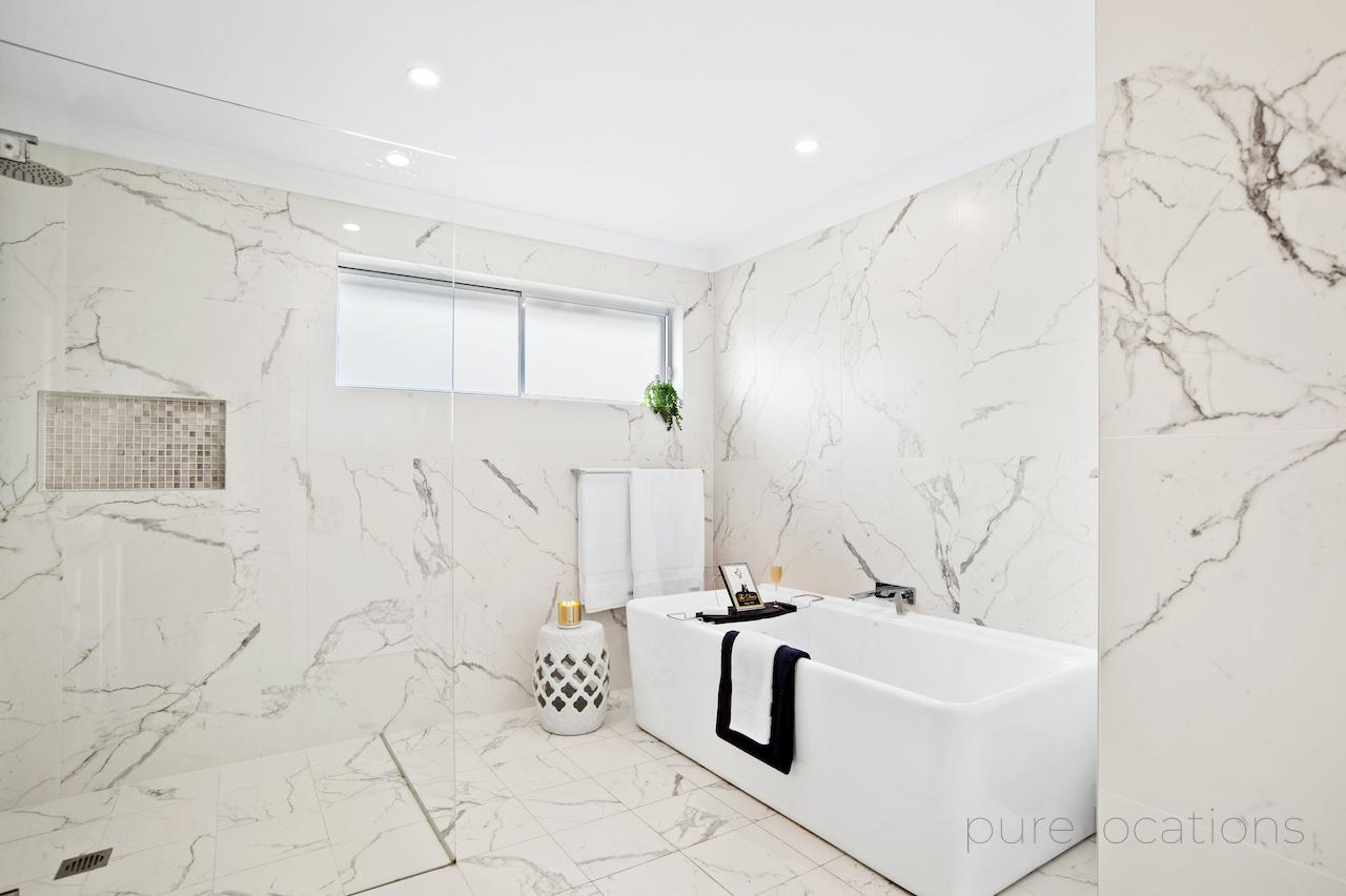 marble look bathroom with free standing bath tub available for filming hire