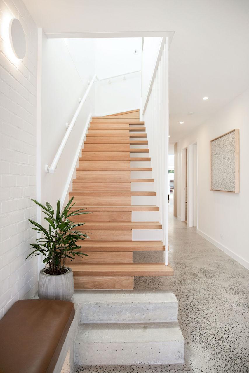 Polished concrete floors with timber stairwell and white walls for photoshoots and film