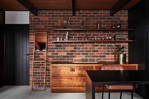 A modern interior with a beautiful brick wall and miid-century modern furniture in a Melbourne Location House