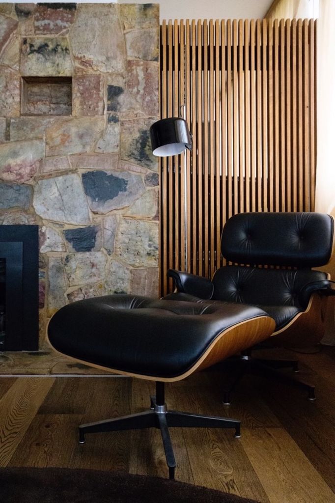 A black leather chair against a wall in a mid-century modern home in Melbourne