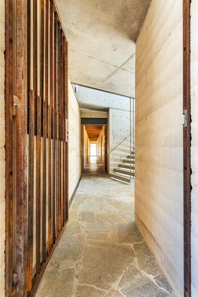 The interior hallway with concrete walls and timber gate in a modern industrial location house on the Central Coast