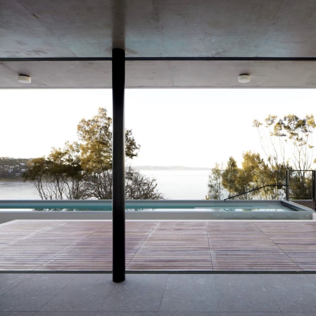 The pool area of a modern industrial home that features concrete
