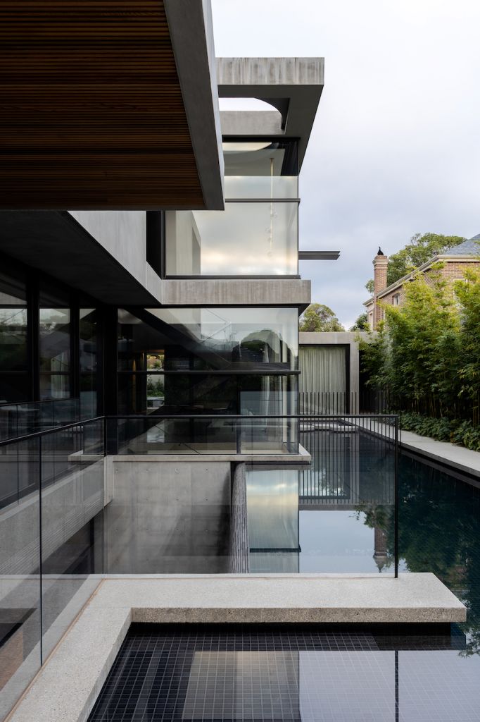 A pool with the exterior of a concrete modern industrial house in Melbourne