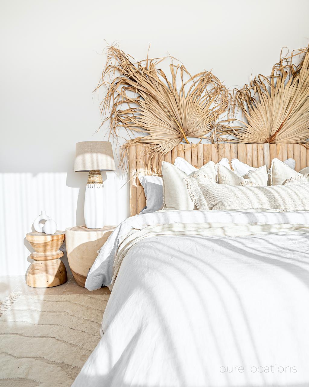Timber bedhead with white linen and timber bedside tables, bohemian decorating style
