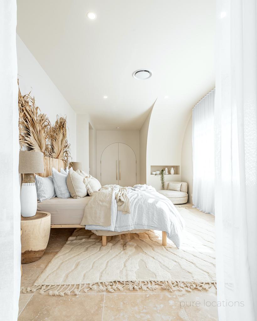 Neutral tones and natural textures create a relaxed master bedroom zone